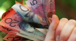 Someone holding a handful of Australian cash.