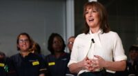 Rachel Reeves speaks in front of nurses, gesturing with her hands and smiling, during a visit to University College London Hospital.