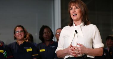 Rachel Reeves speaks in front of nurses, gesturing with her hands and smiling, during a visit to University College London Hospital.