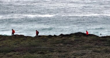 Rescue team members in yellow shirts standing in a circle and talking