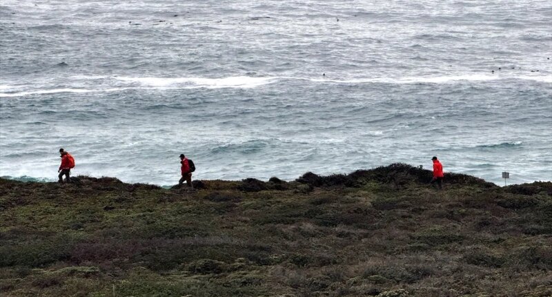 Rescue team members in yellow shirts standing in a circle and talking