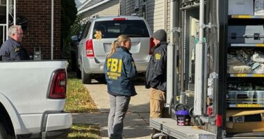 An FBI agent enters a home in Dearborn, Michigan, USA