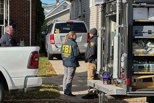 An FBI agent enters a home in Dearborn, Michigan, USA