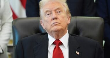 President Donald Trump listens as Health and Human Services Secretary Robert F. Kennedy Jr. speaks during an event about drug prices.