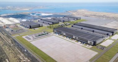 A computer-generated image shows several large, rectangular buildings and surrounding infrastructure at the proposed Teesworks data centre site near the coast.