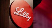 The Eli Lilly logo in white script on a red circular background.