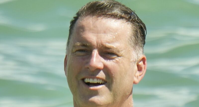 Karl Stefanovic shows off his incredible weight loss as he enjoys a swim at Noosa beach with his brother Peter and sister-in-law Sylvia Jeffreys - one year after THAT 'dad bod' beach photo confession
