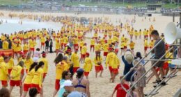 Surf Life savers from Bondi fill the beach after a minutes silence on Saturday, before starting patrol.