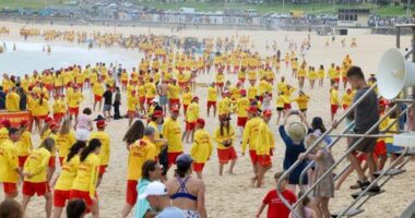 Surf Life savers from Bondi fill the beach after a minutes silence on Saturday, before starting patrol.