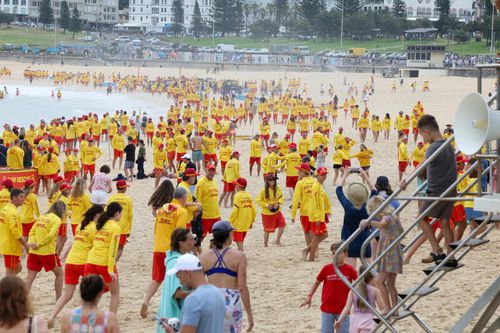 Surf Life savers from Bondi fill the beach after a minutes silence on Saturday, before starting patrol.