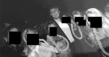 This undated, redacted photo released by Democrats on the House Oversight Committee shows Donald Trump standing with a group of women.