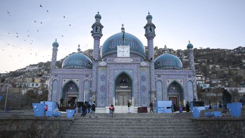 Afghans walk outside Hazara's Sakhi Shrine in Kabul, Afghanistan, Friday, April 19, 2024.