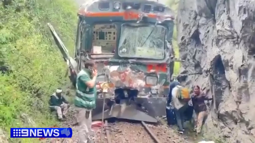 Videos on local media showed train cars with broken windows and dented sides stuck along a rail line hemmed in between a lush forest and a massive rock.