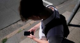 A teenage boy uses his phone for social media in Sydney, Nov. 8, 2024.