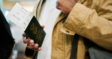 Close-up of male traveler on a vacation holding his passport and boarding pass at airport