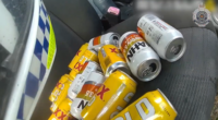 The officer found more than a dozen empty cans of beer under the driver's seat of the red Suzuki.