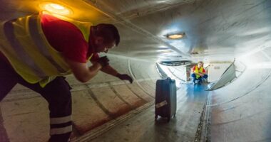 Airplane starts taxiing towards runway with baggage handler trapped