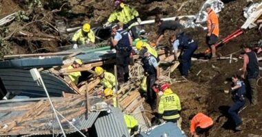 A woman who warned others of a landslide just moments before she was buried in rubble is being hailed a hero as desperate search efforts continue. Multiple children are among those unaccounted for after a big landslide destroyed the popular Mount Maunganui Beachside Holiday Park on New Zealand's North Island. The woman is being praised by locals after she frantically pulled campers from their beds at 5am and warned them of danger so they could start packing up to leave. In a tragic twist, the same woman later became trapped in a toilet block along with several others when the hillside completely collapsed a few hours later, at about 9.30am on Thursday. The amenities block was buried in the landslip, with rescuers hearing terrified screams for help, but being unable to hear further cries after about 15 minutes. 'I just want you to know that one of the women that's in that shower block, she was a hero,' a witness, who didn't want to be named, told the New Zealand Herald. 'She went around at 5 o'clock this morning and she got us all out of bed and she woke us all up so that we could move out... and she's not out.'