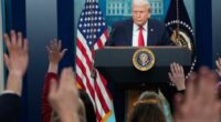 Reporters raise their hands as President Donald Trump speaks during a press briefing at the White House.