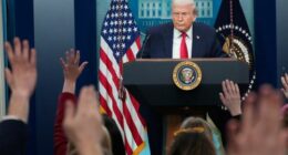Reporters raise their hands as President Donald Trump speaks during a press briefing at the White House.