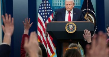 Reporters raise their hands as President Donald Trump speaks during a press briefing at the White House.