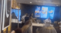 McDonald's customer caught on camera launching flying kick at employee during heated brawl