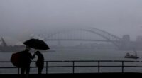 People are seen braving the rain and fog at Mrs Macquaries Chair this morning, Friday, 22 August 2025. After weeks of persistent rain, parts of the NSW coast have now recorded their wettest August in 126 years. Photo: Sam Mooy / The Sydney Morning Herald