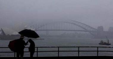 People are seen braving the rain and fog at Mrs Macquaries Chair this morning, Friday, 22 August 2025. After weeks of persistent rain, parts of the NSW coast have now recorded their wettest August in 126 years. Photo: Sam Mooy / The Sydney Morning Herald
