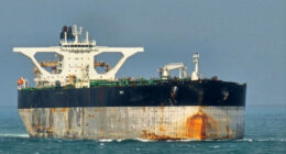 Oil tanker Bella 1 at sea, showing rust stains and large white superstructure, as seen in the Singapore Strait.