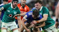 Cian Prendergast tackles France's Antoine Dupont as Ireland captain Caelan Doris looks on
