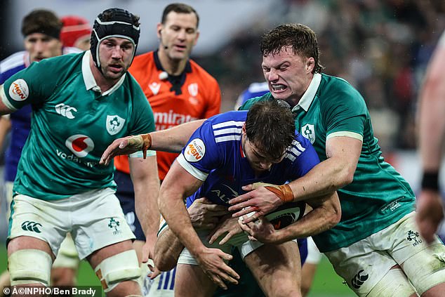 Cian Prendergast tackles France's Antoine Dupont as Ireland captain Caelan Doris looks on