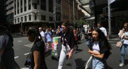Pedestrians move across Market Street in Sydney, Australia.