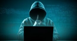 faceless hooded hacker showing silence gesture. Hacker attack. Dangerous Hooded Hacker Breaks into Government Data Servers. Cybersecurity, computer hacker with hoodie. Hacking and malware concept.