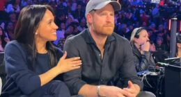 Meghan can't keep her hands off her 'forever Valentine' Harry as she encourages her Prince to smile for the cameras during NBA date night