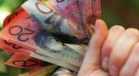 Someone holding a handful of Australian cash.