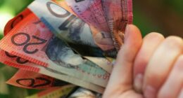Someone holding a handful of Australian cash.
