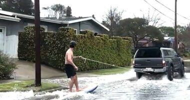 Surfer spotted catching waves on SoCal street during mass flooding