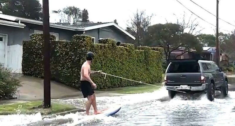 Surfer spotted catching waves on SoCal street during mass flooding