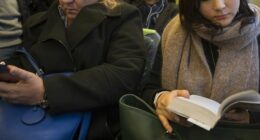 At the end of a work day, commuters ride a metro train traveling from Flinders Street Station to points outside the city center of Melbourne, Australia