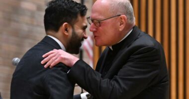 Cardinal Timothy Dolan whispers into Mamdani's ear at NYPD event â as ex-archbishop said he was 'ticked off' at mayoral snubs