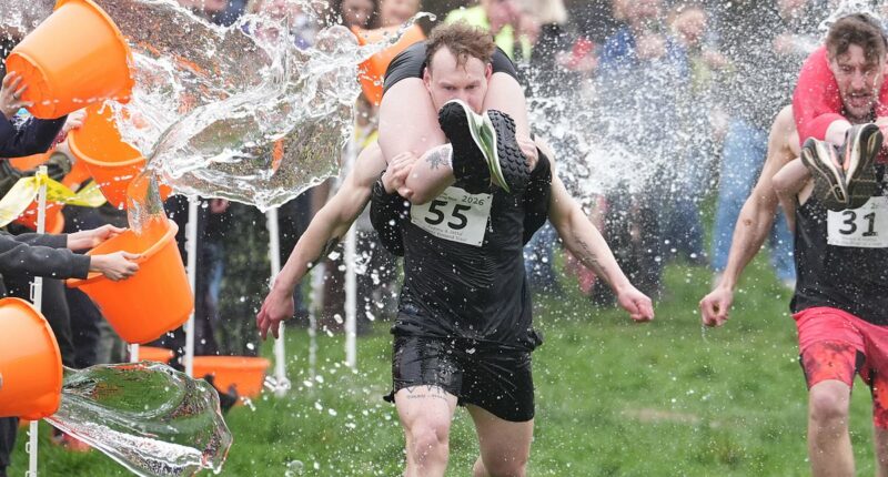 Couples run in the UK wife-carrying race on International Women's Day