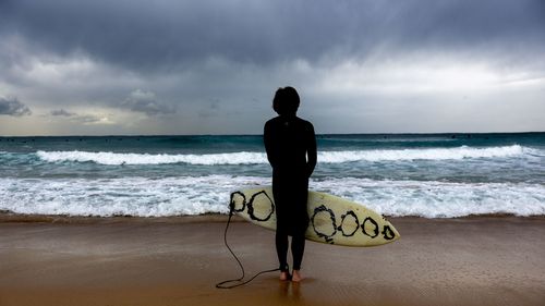 A surfer gauges current conditions at Maroubra beach, ahead of an increased swell in Sydney, Friday, 27 March 2026.