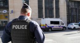 Police stand outside the Bank of America building in Paris, Saturday, March 28, 2026. (AP Photo/Nicolas Garriga)