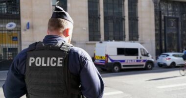 Police stand outside the Bank of America building in Paris, Saturday, March 28, 2026. (AP Photo/Nicolas Garriga)