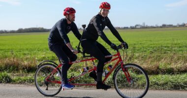 'He's hallucinating!': Prince William pokes fun at Radio 1 DJ Greg James as he jumps on the back of his tandem bike during Comic Relief challenge