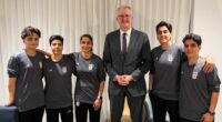 In this photo supplied by Australia's Minister for Home Affairs Tony Burke's office, the Minister Tony Burke, center, poses in an undisclosed location with five Iranian women soccer players who have been granted asylum in Australia, Tuesday, March 10, 2026. (Australia Ministry of Home Affairs via AP)