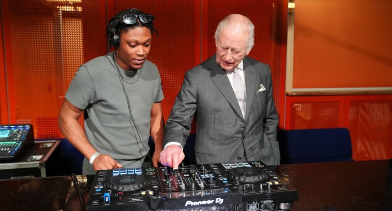 King of the decks! Charles tries his hand at DJing in Manchester - before agreeing 'it's not as easy as it looks'