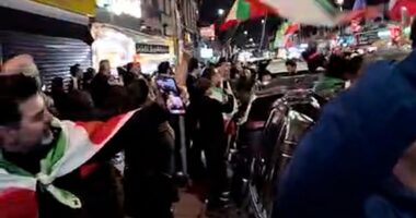London street brought to a standstill as jubilant people blare music, hand out roses, and wave Iranian flags to celebrate the death of Ayatollah Ali Khamenei
