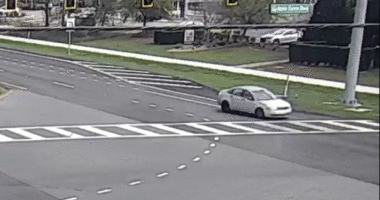 A car drives down a freeway in reverse.