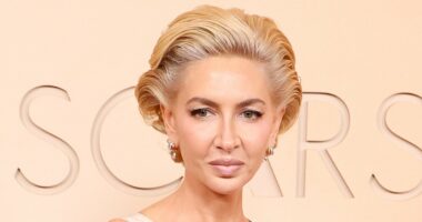 Socialite Sabine Getty's gown gets STUCK in escalator at the Oscars